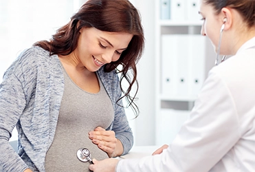 doctor checking pregnant woman's baby's heartbeat