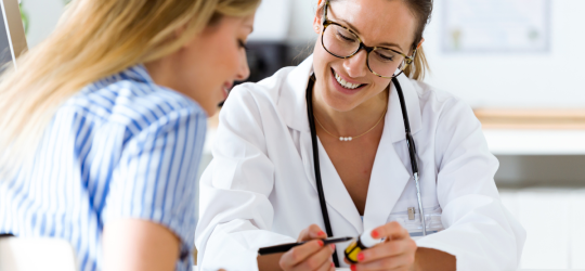 female doctor showing medication to woman