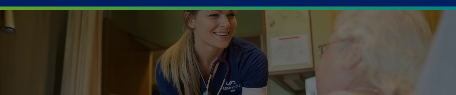 nurse smiling at an elderly patient in bed
