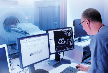 Filip Troicki, MD, Radiation Oncology, doing a scan on a patient