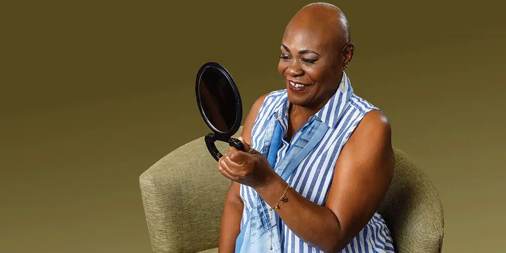 cancer patient looking at herself in a mirror
