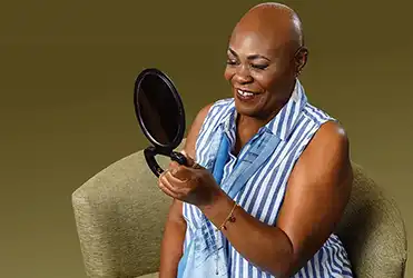 cancer patient holding up a mirror
