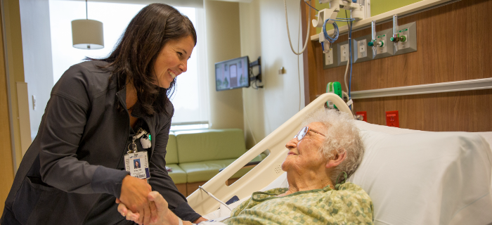 nurse holding hands with elderly patient
