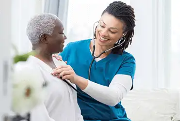 nurse holding a stethoscope on patient chest